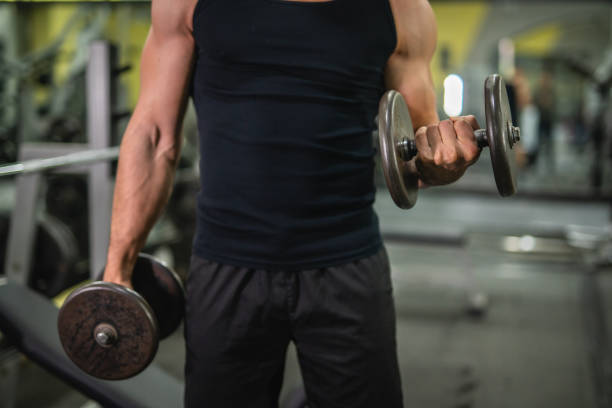 istock close up on muscular man do biceps workouts with dumbbells in gym 2197648354