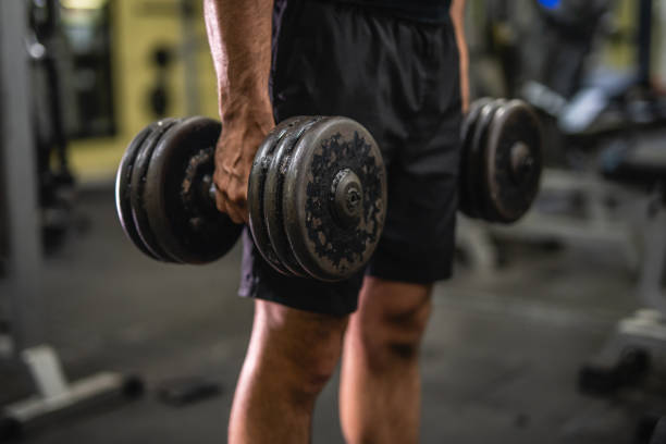 istock close up on unknown muscular man hold dumbbells in the gym 2197650077