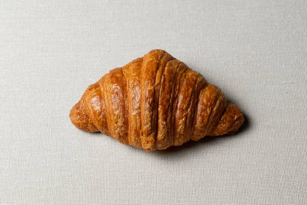 istock Golden croissant resting on a textured tablecloth 2197650500