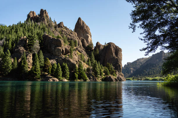 Epic stone formations by tranquil river full of vegetation