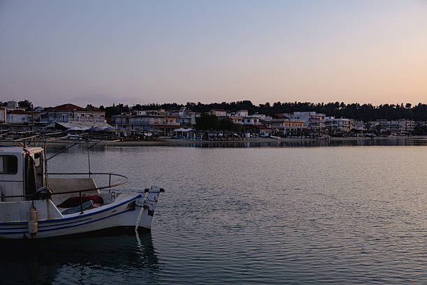 istock Fishing boat and Greek coastline at sunset 2197659586