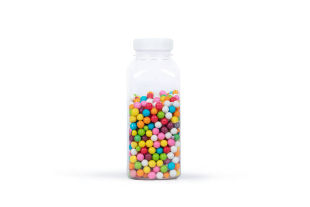 Clear plastic bottle containing multicolored sugar pearls creating a vibrant rainbow effect. Minimalist product photography of confectionery decorations used in baking and cake decoration.