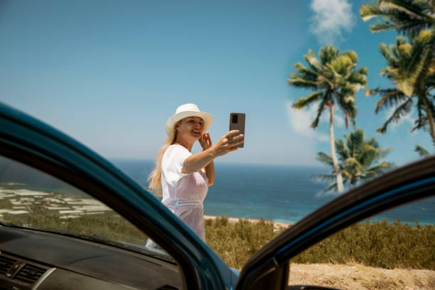 istock Woman using phone taking pictures on her road trip 2197661696