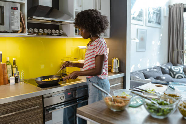 istock Woman cooking pasta in a modern kitchen with fresh ingredients 2197667632