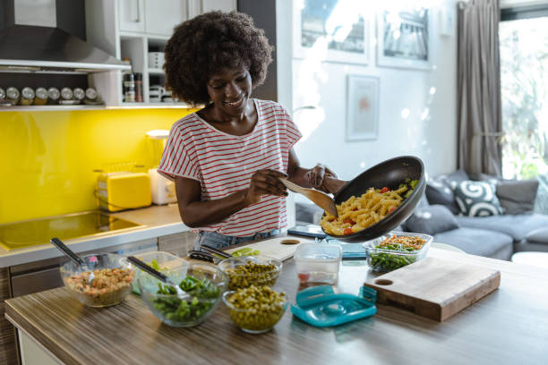 istock Young woman preparing and packing her lunch in a modern kitchen setting 2197667667