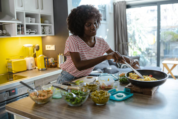 istock Young woman preparing and packing her lunch in a modern kitchen setting 2197667668