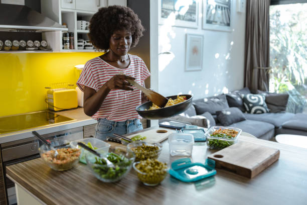 istock Woman cooking and organizing fresh meals in a well-lit modern kitchen space 2197667671
