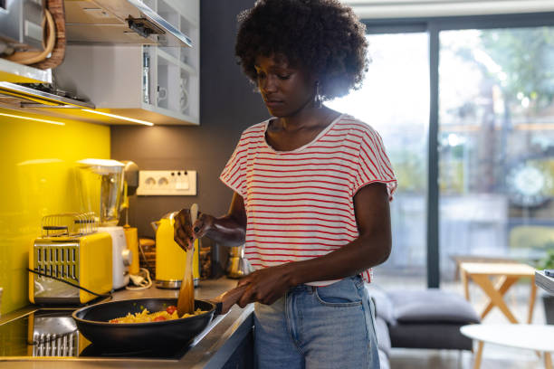 istock Woman preparing a meal in a modern kitchen with natural light 2197667822