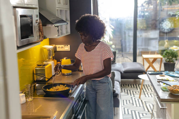 istock Woman preparing a meal in a modern kitchen with natural light 2197667905