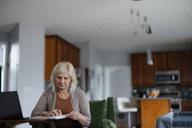 istock Mature Woman Reviewing Documents at Home with a Thoughtful Expression 2197674069