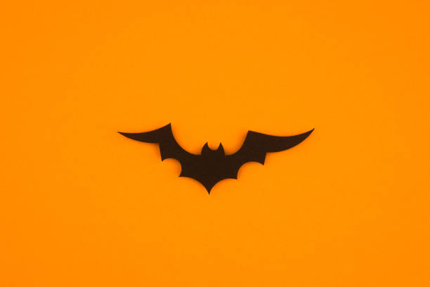istock Dark bat silhouette on bright orange background captures Halloween spirit 2197674504