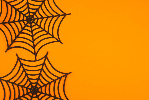 istock Black spider webs on a bright orange background create a striking autumn decoration 2197674516