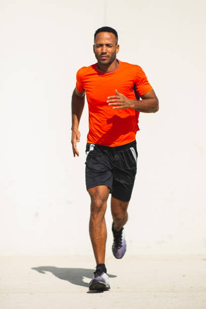 Young man in sportswear  jogging outdoors in city on a bright sunny day