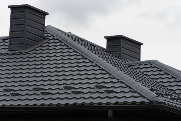 istock Two metal chimneys on a house roof under a cloudy sky 2197675411