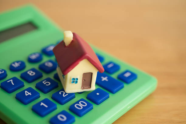 istock Close up cute house on green calculator background. 2197675529