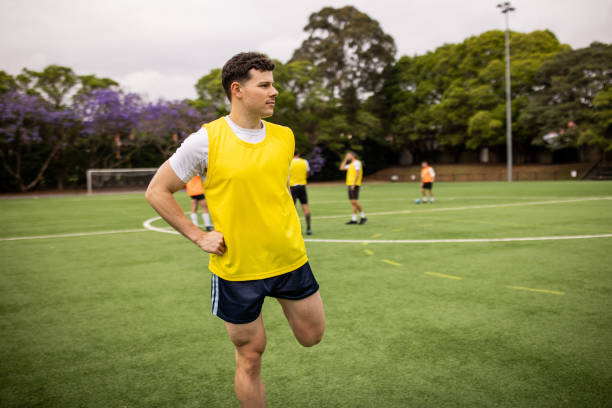 istock Soccer Player Warming Up with Leg Stretches 2197676654