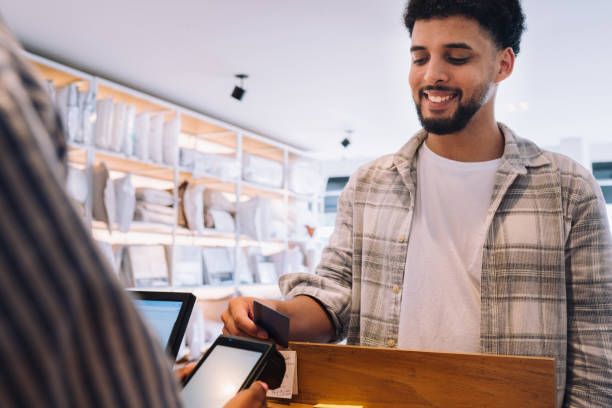 istock Smiling customer paying for merchandise with his credit card 2197678692