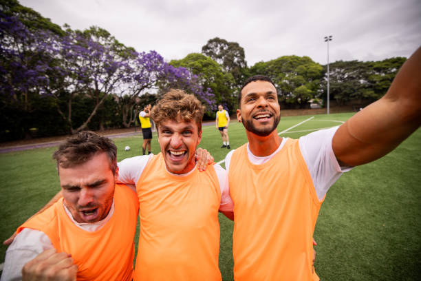 Soccer players celebrate a teammate’s goal with an emotional embrace, expressing their shared happiness and excitement after scoring during the match.
