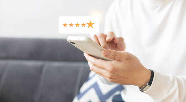 istock close up on customer man hand check on gold five star rating feedback icon and press level best rank  for give score point to review the service business concept 2197685113