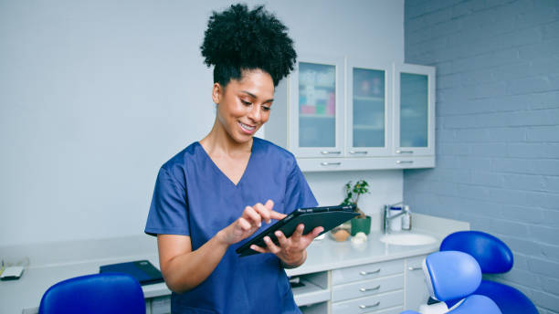 istock Confident Dental Professional Using Tablet in Modern Office Ready to Assist Patients 2197685982