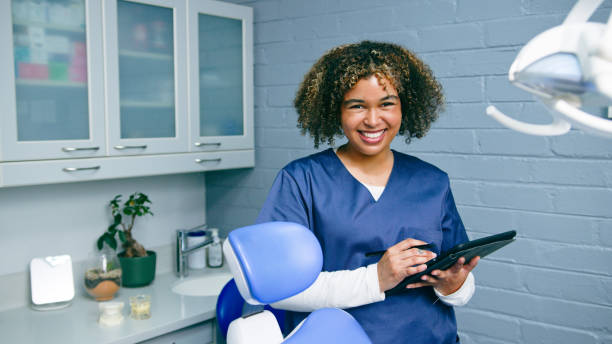 istock Smiling Dental Professional Holding Tablet in Modern Clinic 2197686033