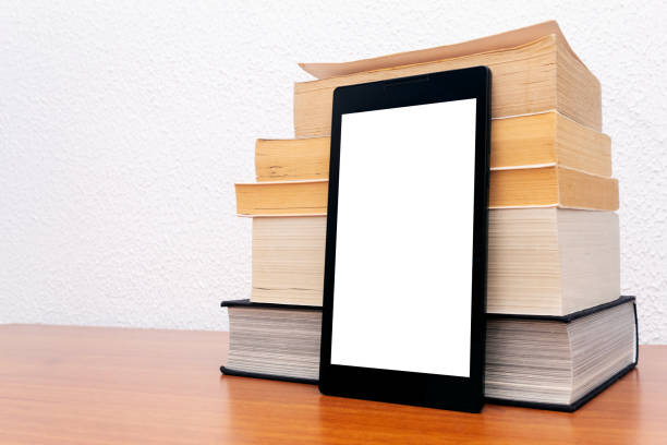 istock Tablet with blank screen in front of a stack of physical books. Classic and digital reading. E-book, electronic book 2197686742