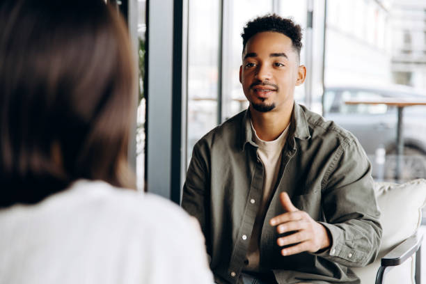 istock Young man explaining something to colleague during business meeting in cafe 2197687305