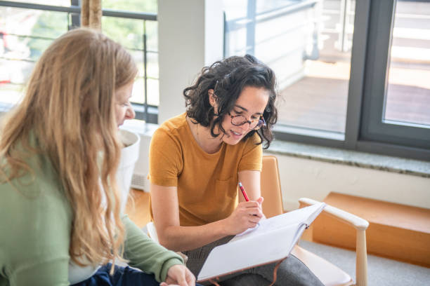 istock Caucasian And Hispanic Businesswoman Discussing Notes In Office 2197688562