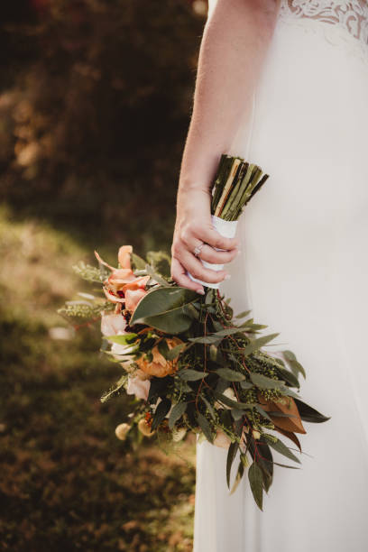 istock Bride holding wedding flowers bouquet with wedding ring on hand 2197689491