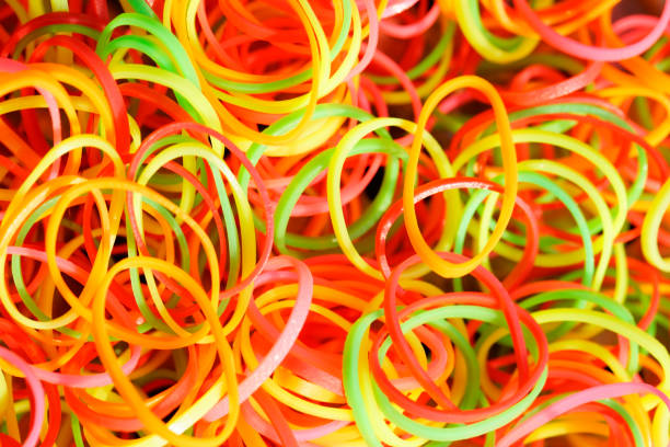 A vibrant collection of colorful rubber bands showcasing a mix of yellow, red, green, and orange tones. Perfect for crafting or office supplies.