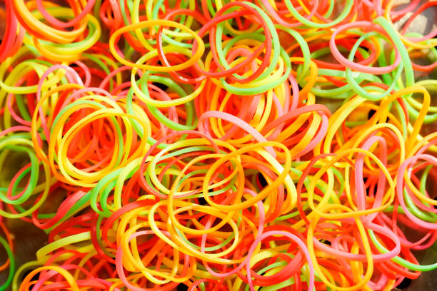 A vibrant assortment of colorful rubber bands in shades of pink, green, and orange, perfect for creative projects, organization, or playful activities.