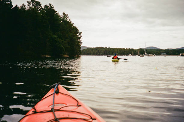 istock Kayakers paddling on a calm lake under an overcast sky, 2197695244