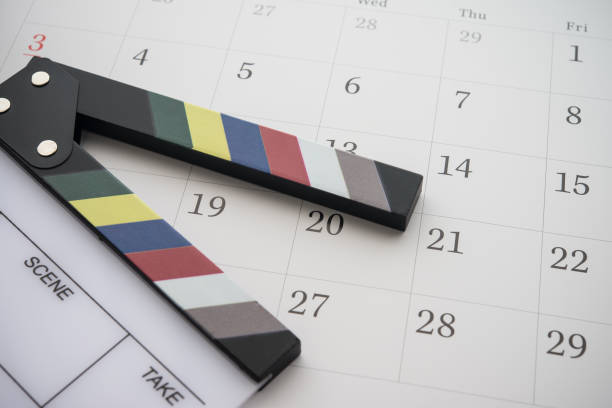 White cinema clapperboard on blank white calendar background copy space.