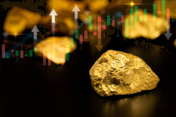 istock Pure gold ore found in mine on black background with fluctuating gold price graph 2197699642