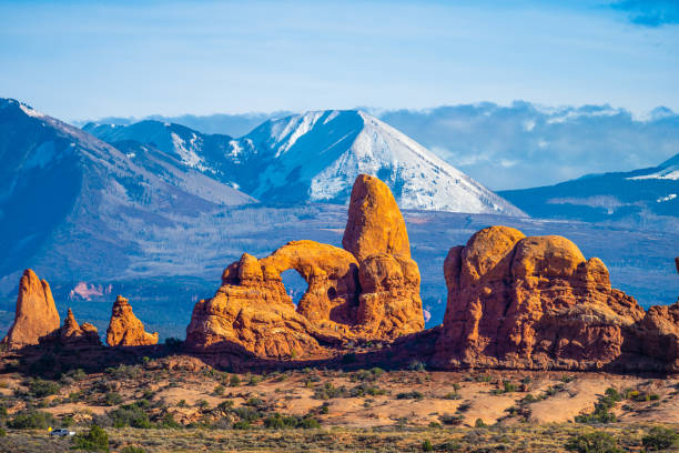 Breathtaking landscapes of Arches National Park in Utah, featuring stunning rock formations, natural arches, and snow-capped mountains in the background. This iconic scene captures the dramatic beauty of the American Southwest’s rugged desert terrain.