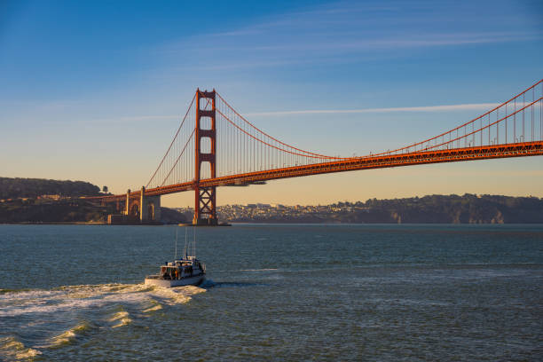 The iconic Golden Gate Bridge in San Francisco, California, with a boat cruising through the bay. This stunning view captures the world-famous suspension bridge, deep blue waters, and the beauty of the city’s coastline.