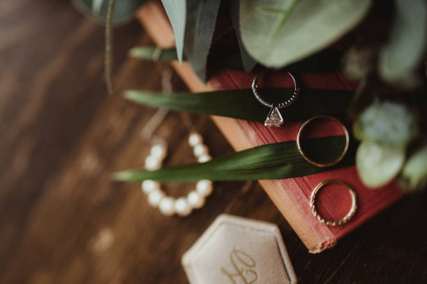 Photo of wedding rings directly above with greenery and wood background