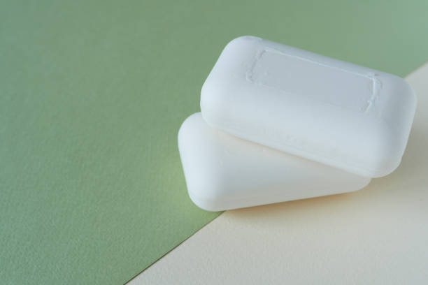 istock White soap on green and white paper background. Copy space for text. 2197704009