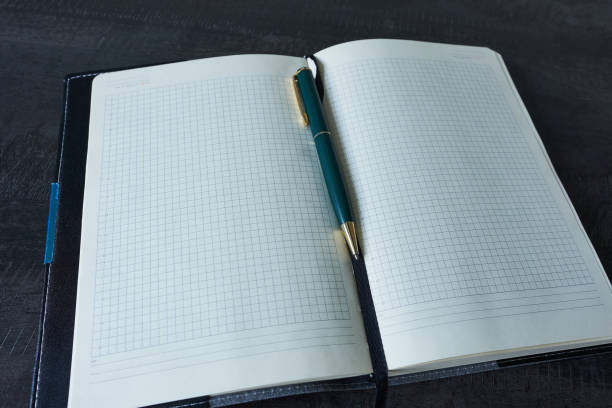 istock A diary and a pen on a black desk. Close-up. 2197704026