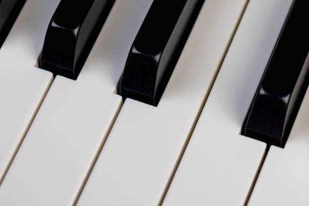 black and white piano keys in close-up, part of a piano or grand piano keyboard in white and black to create musical compositions
