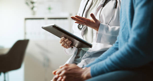 istock Hands, doctor and patient with tablet, consultation and conversation with feedback for diagnosis. People, closeup and medical insurance with professional, man and tech for online results and talking 2197708840