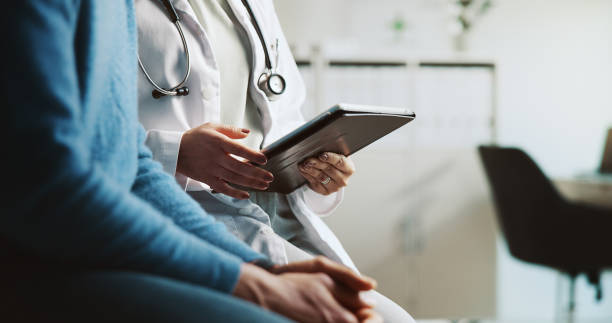 istock Hands, doctor and patient with tablet, feedback and conversation with diagnosis. People, closeup and medical insurance with professional, man and tech for online report, internet and consultation 2197708845