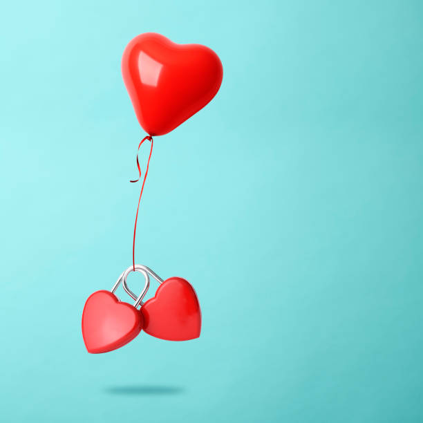 istock Two red heart shaped padlock with heart shaped balloon floating in mid- air 2197709982