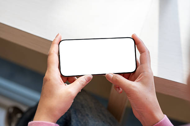 Top view of a woman's hand holding a smartphone horizontally while watching a video.