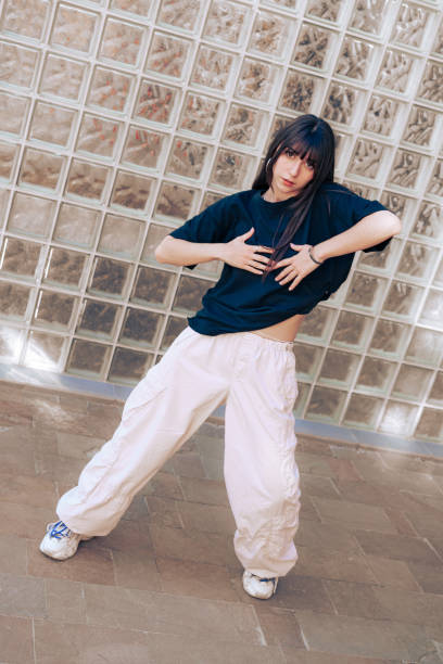 istock Young dancer performs expressive movements in urban setting during a sunny day in summer wearing casual streetwear 2197712209