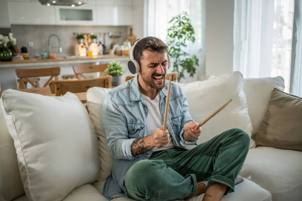 istock Young man with headphones playing imaginary drums 2197713809