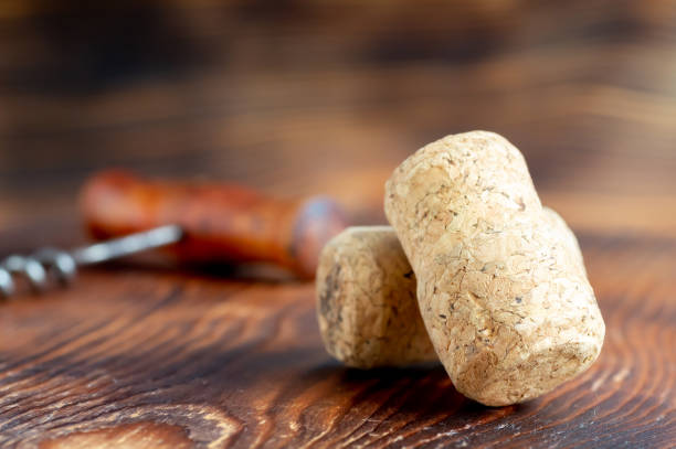 istock Two wine corks close-up, with a corkscrew in the background, on a wooden background 2197716133
