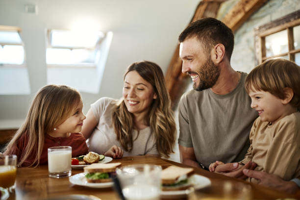 istock Happy parents and their kids talking during breakfast at dining table. 2197716429