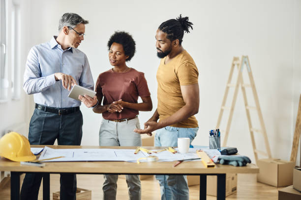 istock Male architect using touchpad with black couple during home renovation process. 2197717302