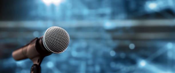 istock Public speaking backgrounds, Close-up the microphone on stand for speaker speech at seminar room with technology light background and blur bokeh. 2197717691